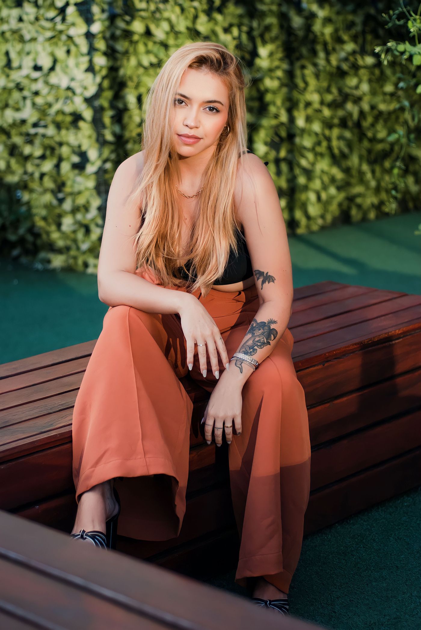 Wide-leg rust trousers worn with a black sleeveless top