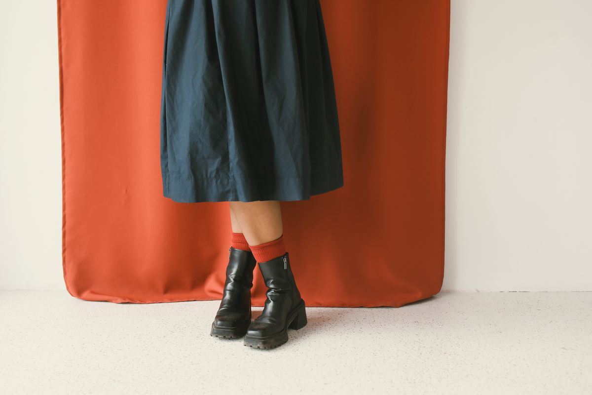 A dark midi skirt with ankle boots and red socks