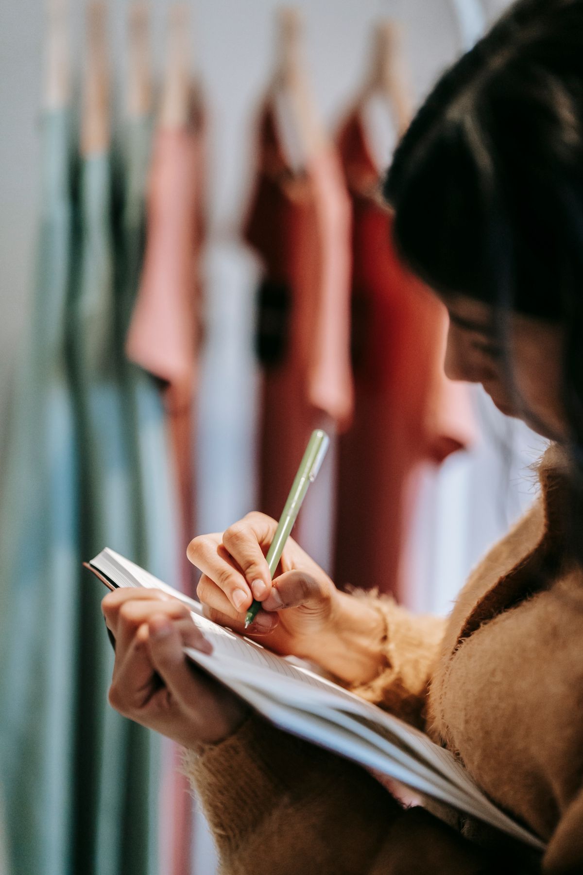 A notebook used beside a rail of clothes