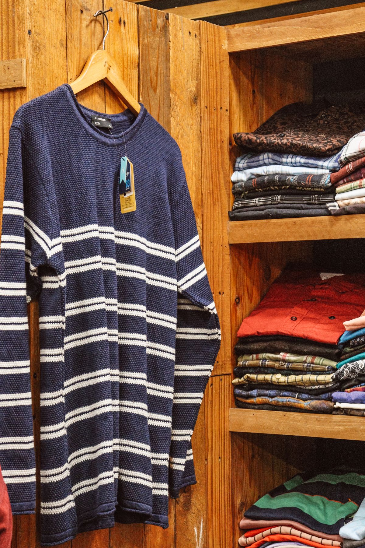 Hanging and folded clothes in a compact wooden wardrobe