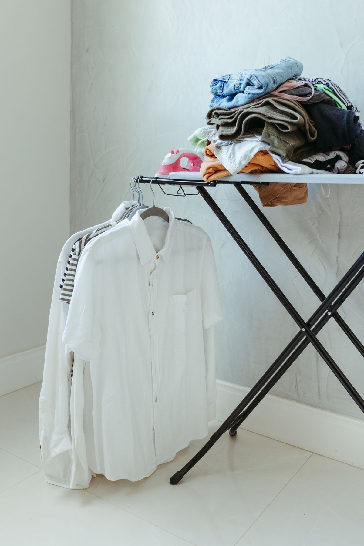Folded clothes beside shirts on hangers