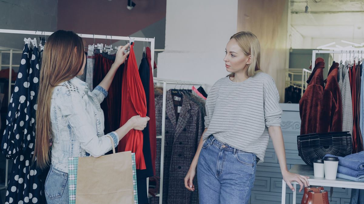 Two women considering clothing on a shop rail