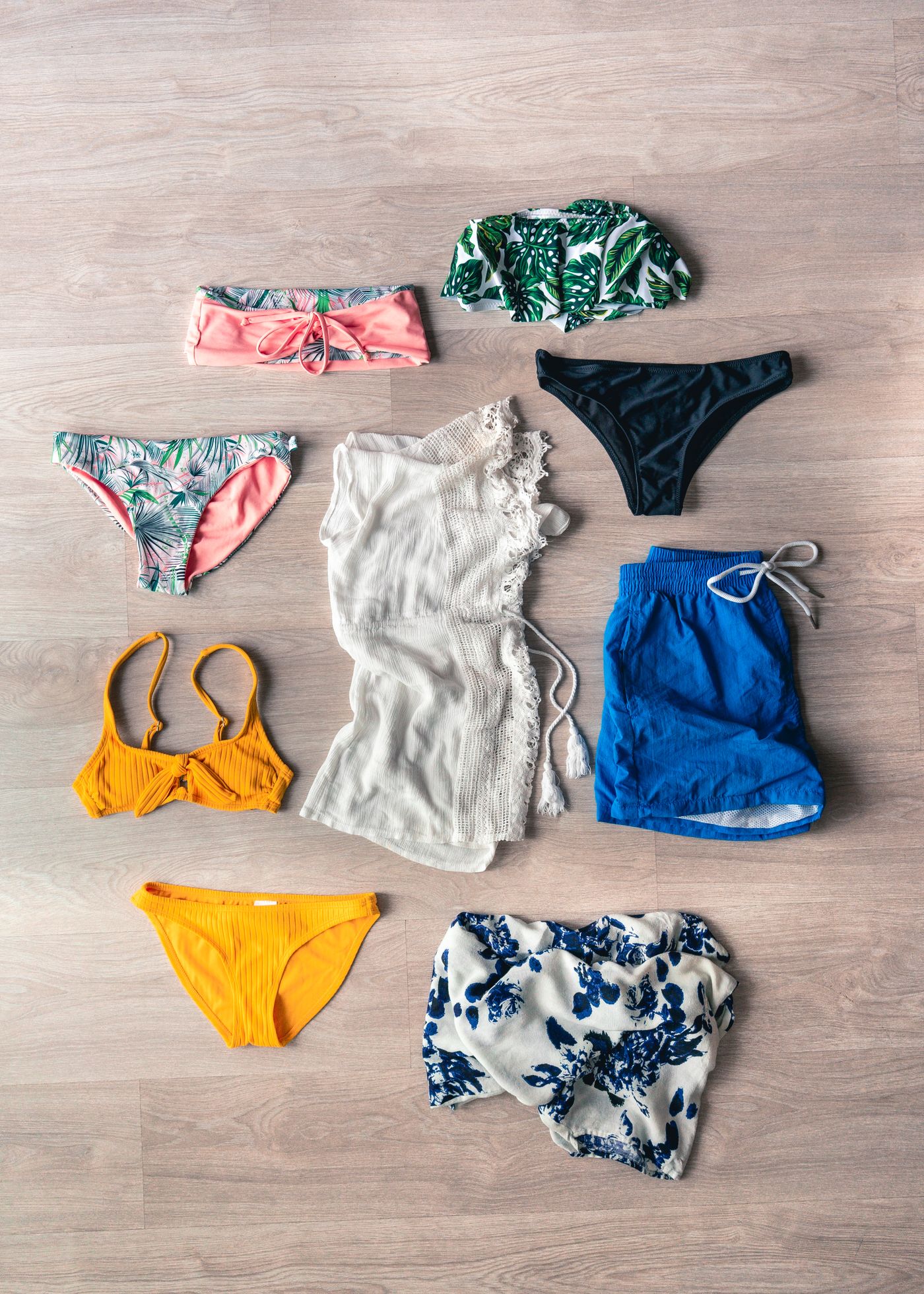 Swimwear laid out on a wooden floor