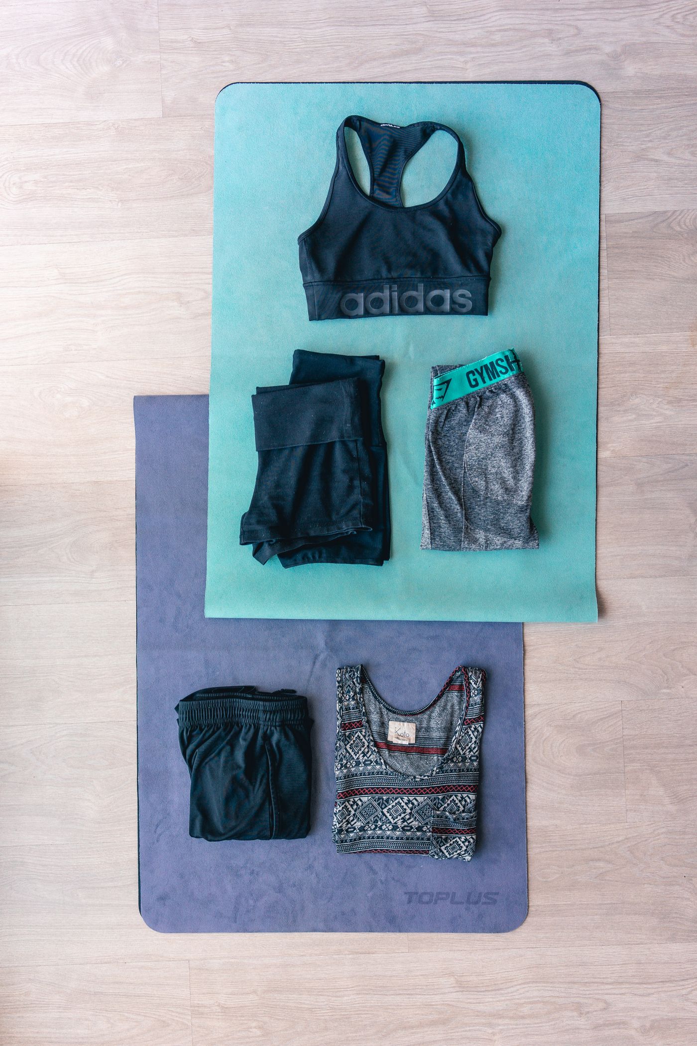 Sports tops and shorts arranged on exercise mats