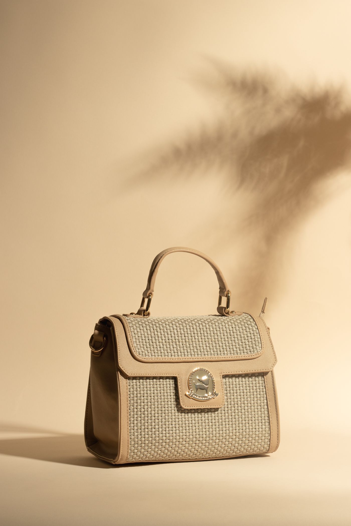A structured beige handbag with a top handle