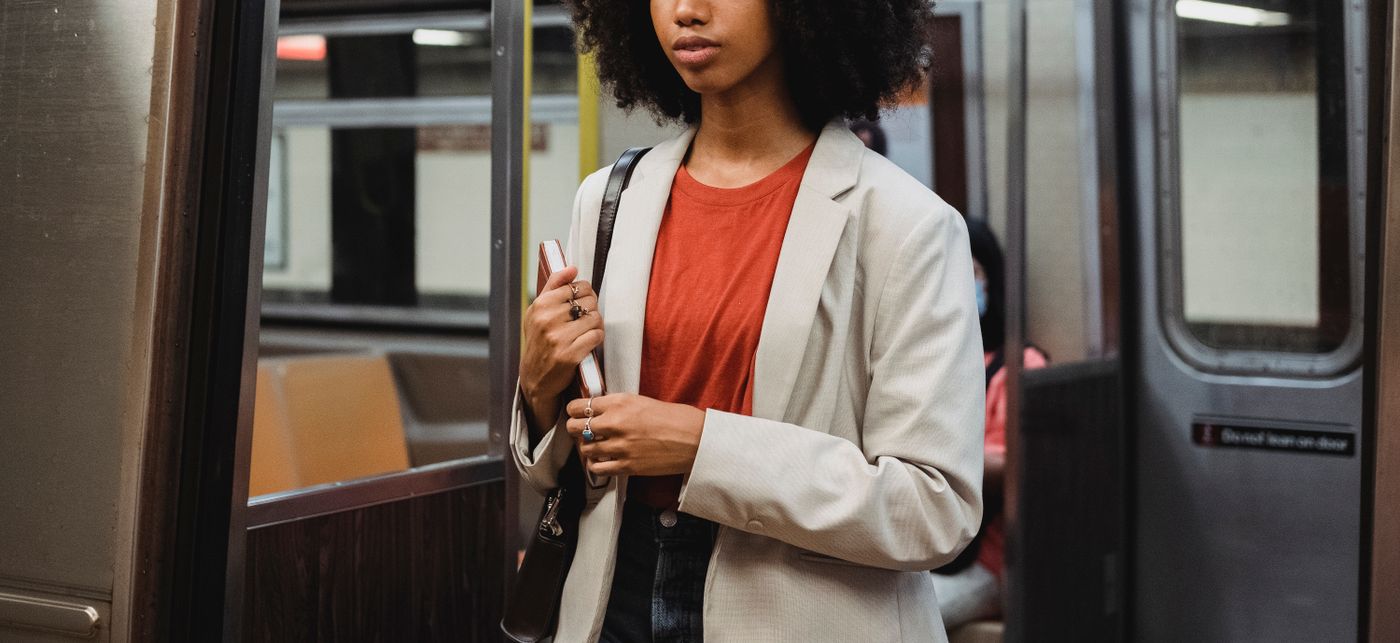 A woman wearing a blazer while travelling on a train