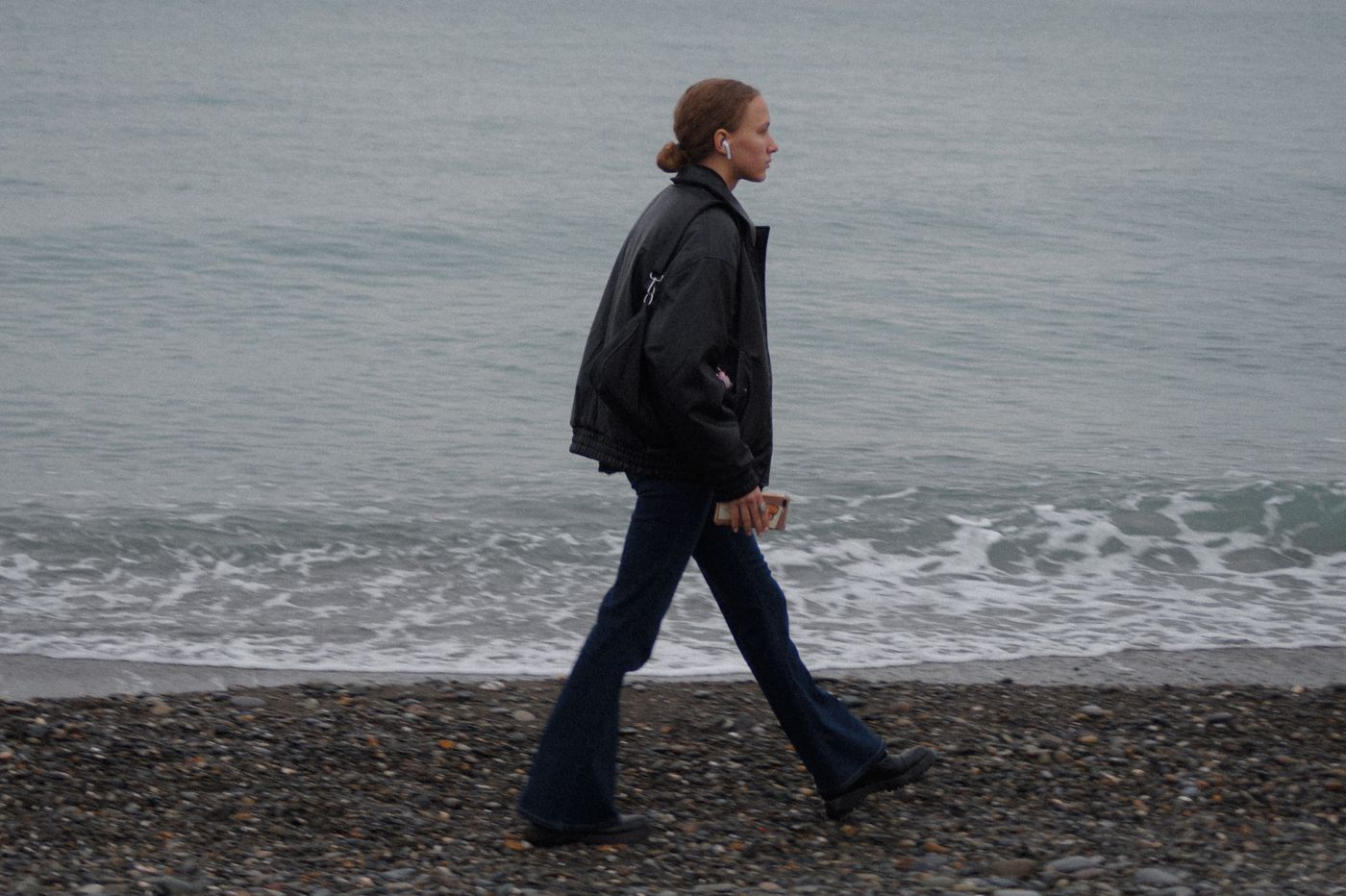 A jacket and jeans worn on a pebble beach