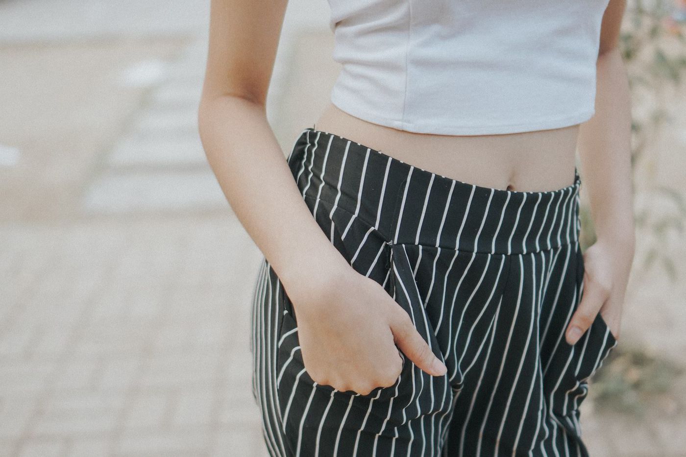 Hands resting in the pockets of striped trousers