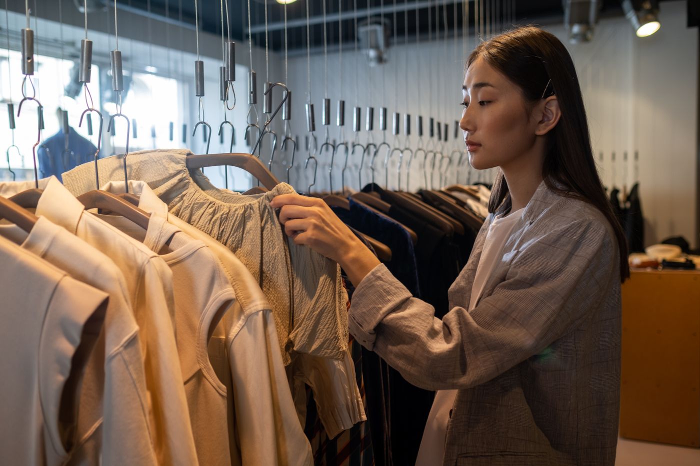 A shopper examining clothes on a rail